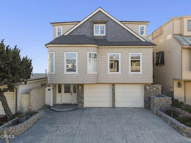 4177 Ocean Dr, Oxnard, CA 93035 - view of front facade with stone siding, an attached garage, driveway, and roof with shingles