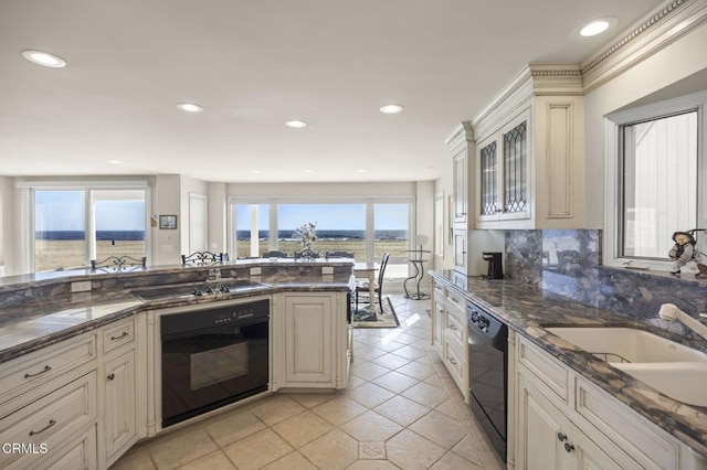4177 Ocean Dr, Oxnard, CA 93035 - kitchen with black appliances, light tile patterned floors, backsplash, a sink, and glass insert cabinets
