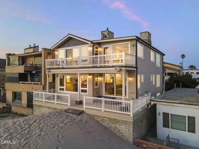 4177 Ocean Dr, Oxnard, CA 93035 - back of property at dusk with a chimney and a balcony