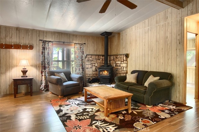2843 E Westfall Rd, Mariposa, CA 95338 - living area featuring a wood stove, wood-type flooring, a ceiling fan, and wood walls