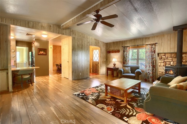 2843 E Westfall Rd, Mariposa, CA 95338 - living room with a wood stove, light wood-style floors, wood walls, and ceiling fan