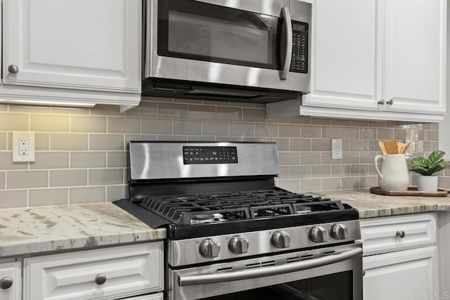 2778 Carlsbad Blvd Unit 201, Carlsbad, CA 92008 - kitchen featuring appliances with stainless steel finishes, backsplash, and white cabinetry