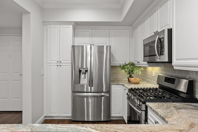 2778 Carlsbad Blvd Unit 201, Carlsbad, CA 92008 - kitchen with appliances with stainless steel finishes, white cabinets, dark wood-style floors, light stone counters, and backsplash