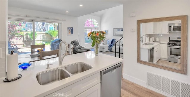 2693 Lookout Cir, Chino Hills, CA 91709 - kitchen featuring appliances with stainless steel finishes, a sink, white cabinets, light wood-style floors, and recessed lighting
