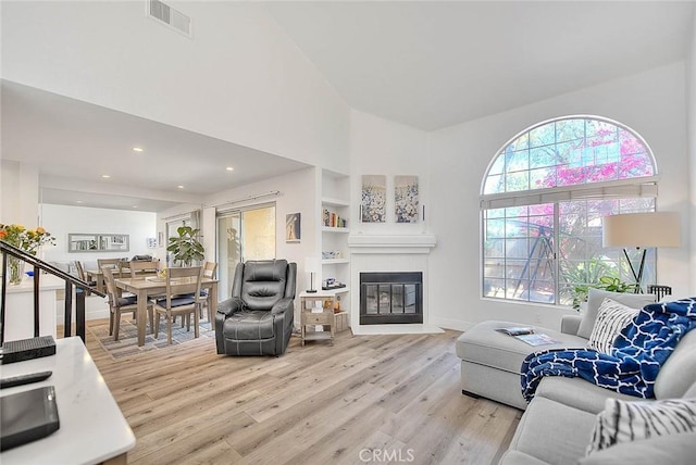 2693 Lookout Cir, Chino Hills, CA 91709 - living area featuring light wood-type flooring, a towering ceiling, a fireplace, built in shelves, and recessed lighting