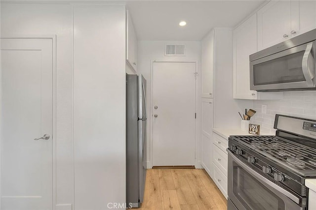 2693 Lookout Cir, Chino Hills, CA 91709 - kitchen with stainless steel appliances, white cabinets, light wood-type flooring, decorative backsplash, and recessed lighting