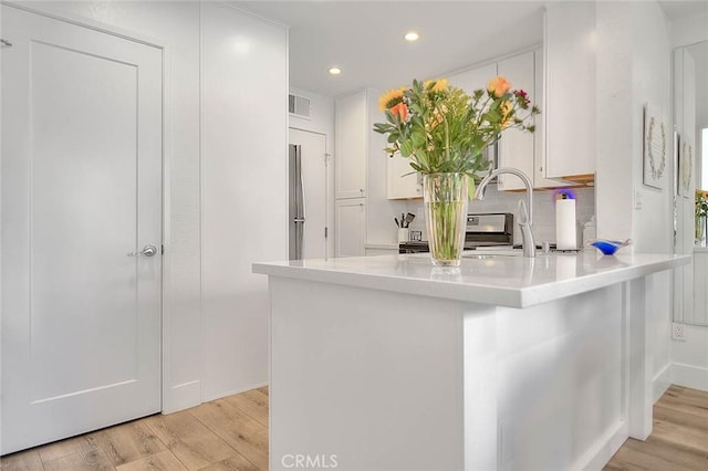 2693 Lookout Cir, Chino Hills, CA 91709 - kitchen featuring light wood-style flooring, white cabinets, recessed lighting, a peninsula, and light countertops