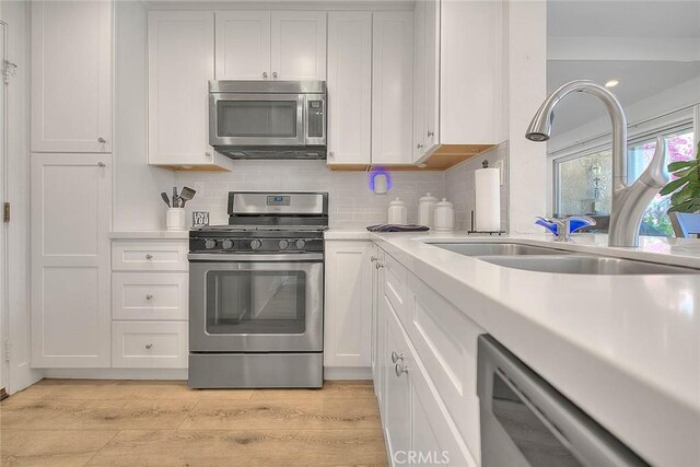 2693 Lookout Cir, Chino Hills, CA 91709 - kitchen with stainless steel appliances, light countertops, a sink, and light wood-style flooring