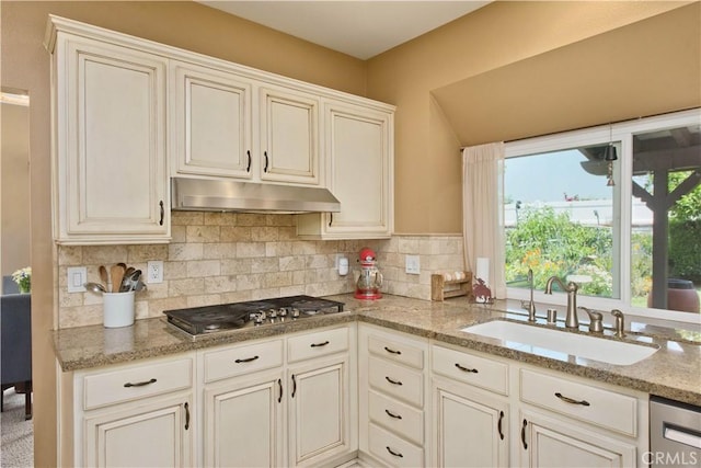 22447 Poplar St, Saugus, CA 91390 - kitchen featuring appliances with stainless steel finishes, a sink, under cabinet range hood, decorative backsplash, and light stone countertops