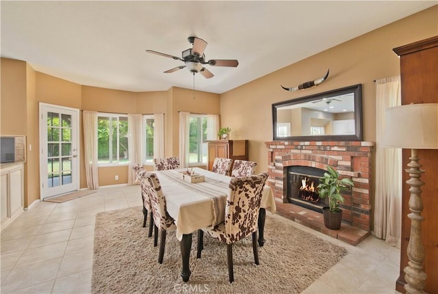 22447 Poplar St, Saugus, CA 91390 - dining room featuring light tile patterned floors, a ceiling fan, a brick fireplace, and baseboards