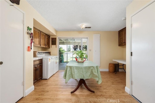 3298 N Zediker Ave, Sanger, CA 93657 - kitchen featuring washing machine and dryer, light countertops, a textured ceiling, light wood-style flooring, and baseboards