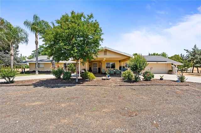 3298 N Zediker Ave, Sanger, CA 93657 - view of front facade with concrete driveway, solar panels, a garage, and stucco siding