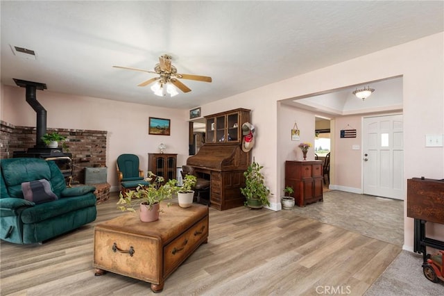 3298 N Zediker Ave, Sanger, CA 93657 - living room featuring a wood stove, a ceiling fan, light wood-style flooring, and baseboards