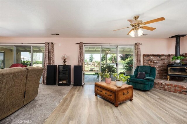 3298 N Zediker Ave, Sanger, CA 93657 - living area with a wood stove, wood finished floors, and a ceiling fan