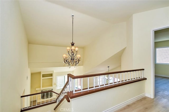 13855 Calada Dr, Moreno Valley, CA 92553 - corridor with an upstairs landing, wood finished floors, a chandelier, and baseboards