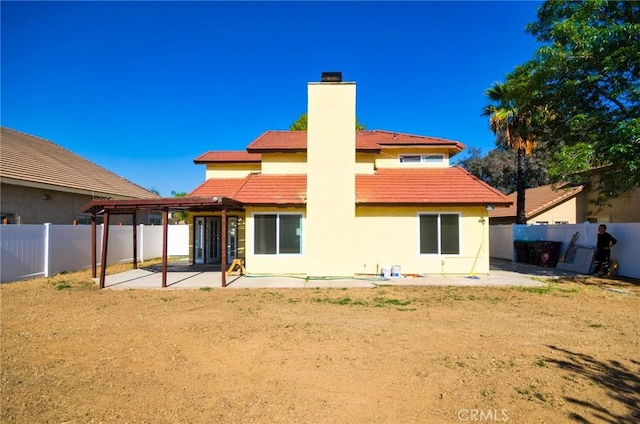 13855 Calada Dr, Moreno Valley, CA 92553 - back of property featuring a patio area, a chimney, a fenced backyard, and a tile roof