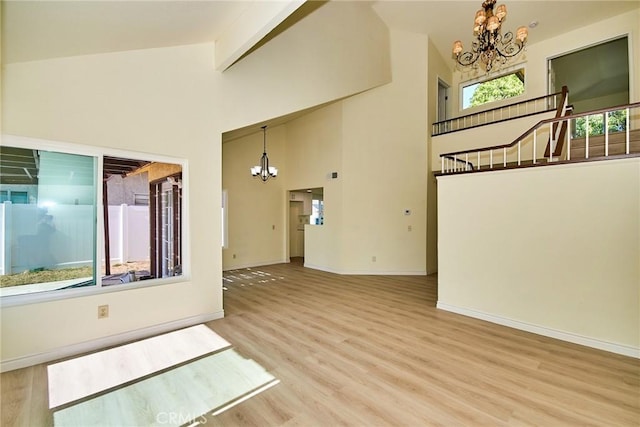 13855 Calada Dr, Moreno Valley, CA 92553 - unfurnished room featuring a chandelier, wood finished floors, baseboards, high vaulted ceiling, and beamed ceiling