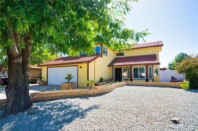 13855 Calada Dr, Moreno Valley, CA 92553 - view of front facade with driveway, an attached garage, stucco siding, and a tiled roof