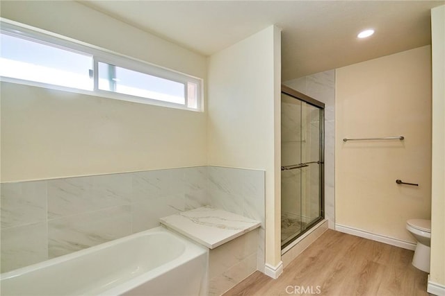 13855 Calada Dr, Moreno Valley, CA 92553 - bathroom with a garden tub, toilet, a stall shower, wood finished floors, and baseboards