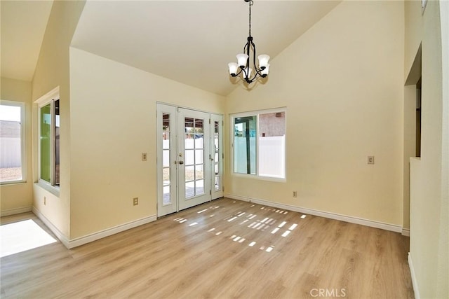 13855 Calada Dr, Moreno Valley, CA 92553 - unfurnished dining area with a chandelier, healthy amount of natural light, light wood finished floors, baseboards, and high vaulted ceiling