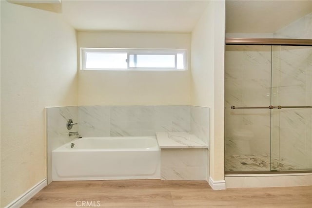 13855 Calada Dr, Moreno Valley, CA 92553 - bathroom featuring a bath, wood finished floors, a stall shower, and baseboards