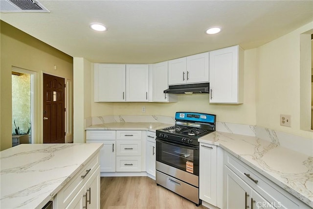 13855 Calada Dr, Moreno Valley, CA 92553 - kitchen with gas stove, under cabinet range hood, light wood-type flooring, white cabinets, and recessed lighting