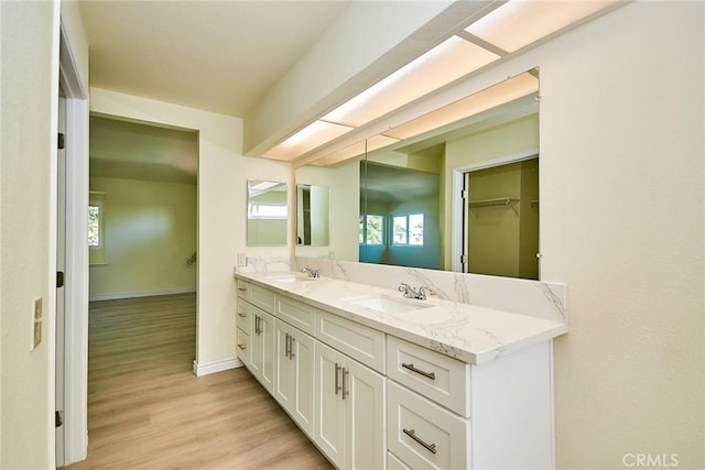 13855 Calada Dr, Moreno Valley, CA 92553 - full bathroom featuring double vanity, wood finished floors, and baseboards