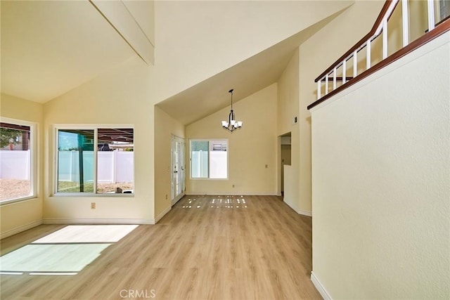 13855 Calada Dr, Moreno Valley, CA 92553 - empty room with light wood-style flooring, a chandelier, healthy amount of natural light, high vaulted ceiling, and baseboards