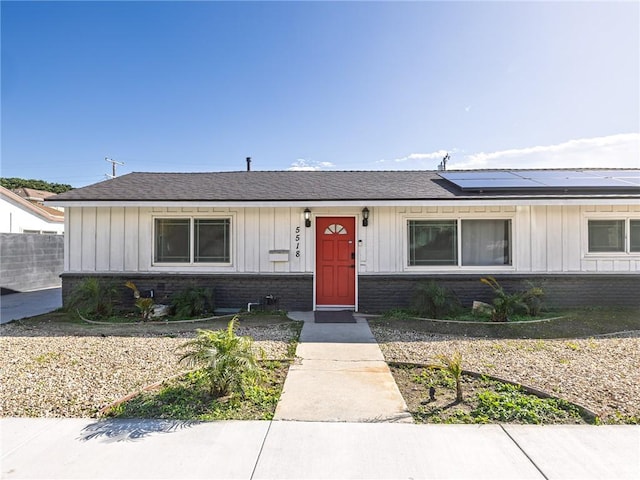 5518 W 117th St, Hawthorne, CA 90304 - bungalow-style home with solar panels, board and batten siding, brick siding, and a shingled roof