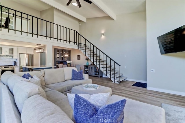 259 Calle Aragon Unit A, Laguna Woods, CA 92637 - living room with stairs, beamed ceiling, wood finished floors, ceiling fan, and baseboards