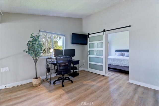 259 Calle Aragon Unit A, Laguna Woods, CA 92637 - home office with vaulted ceiling, wood finished floors, baseboards, and a barn door