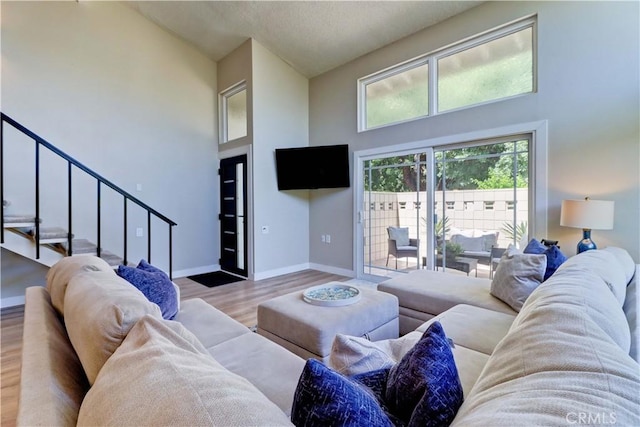 259 Calle Aragon Unit A, Laguna Woods, CA 92637 - living room featuring high vaulted ceiling, wood finished floors, stairway, and baseboards