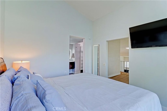259 Calle Aragon Unit A, Laguna Woods, CA 92637 - bedroom featuring a high ceiling, baseboards, and wood finished floors