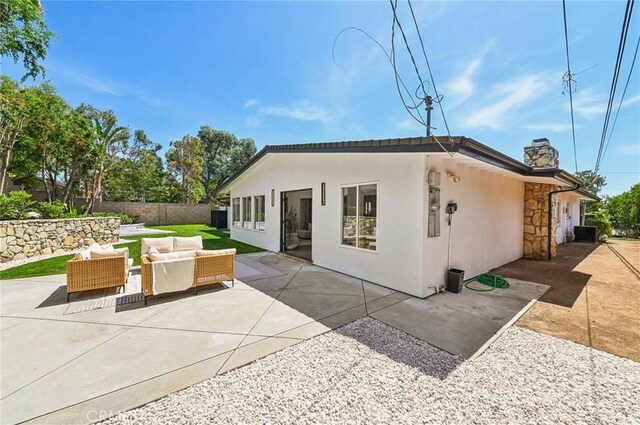 4816 Saint Andrews Ave, Buena Park, CA 90621 - rear view of property featuring an outdoor living space, a patio, a chimney, stucco siding, and stone siding