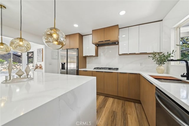 4816 Saint Andrews Ave, Buena Park, CA 90621 - kitchen featuring appliances with stainless steel finishes, a sink, white cabinetry, wood finished floors, and hanging light fixtures