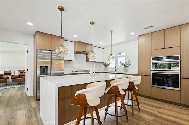 4816 Saint Andrews Ave, Buena Park, CA 90621 - kitchen with appliances with stainless steel finishes, light wood-style floors, modern cabinets, a center island, and recessed lighting