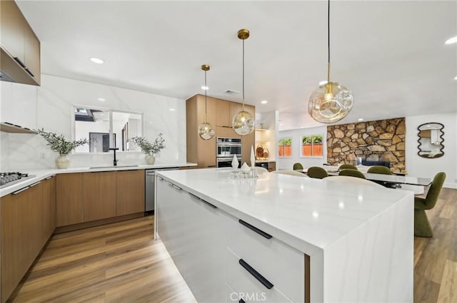 4816 Saint Andrews Ave, Buena Park, CA 90621 - kitchen featuring modern cabinets, a sink, a fireplace, light countertops, and light wood finished floors