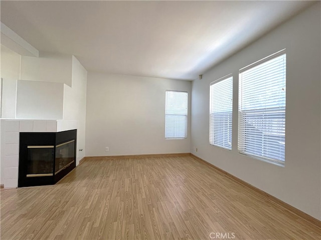 1729 Sunflower Ave Unit A, Glendora, CA 91740 - unfurnished living room featuring light wood finished floors, a tiled fireplace, and baseboards
