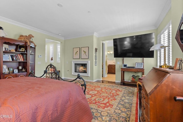 4003 Galapagos Way, Oxnard, CA 93035 - bedroom featuring multiple windows, crown molding, a glass covered fireplace, wood finished floors, and baseboards