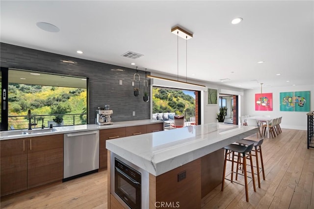 1435 Cerritos Dr, Laguna Beach, CA 92651 - kitchen featuring stainless steel dishwasher, a sink, modern cabinets, recessed lighting, and a breakfast bar