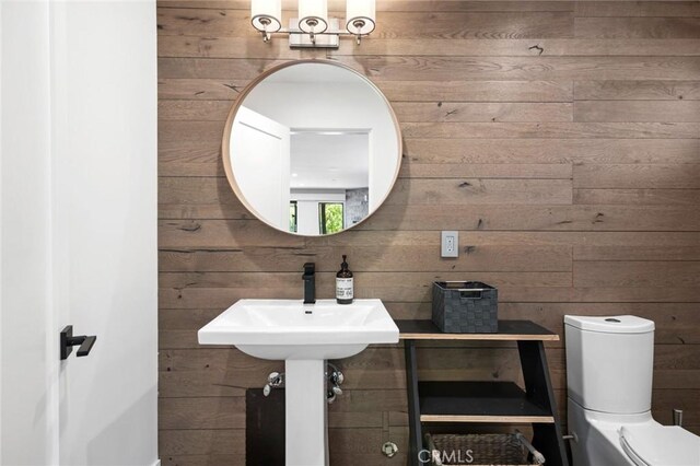 1435 Cerritos Dr, Laguna Beach, CA 92651 - half bathroom with wooden walls, toilet, and a sink