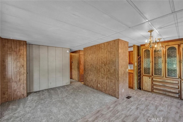 15993 27th Ave, Clearlake, CA 95422 - unfurnished living room with wooden walls, a chandelier, and light carpet