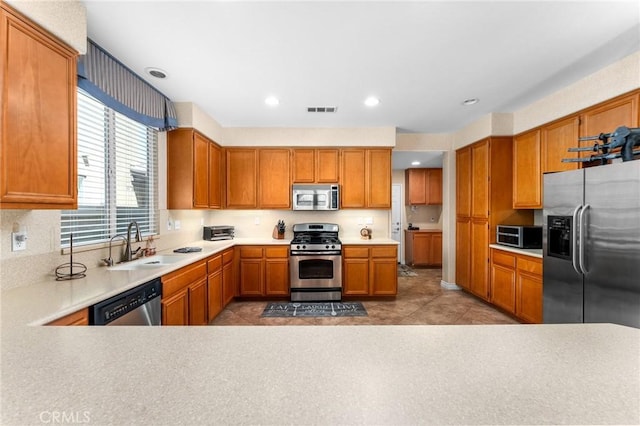 35509 Trevino Trl, Beaumont, CA 92223 - kitchen featuring stainless steel appliances, a sink, light countertops, brown cabinets, and recessed lighting