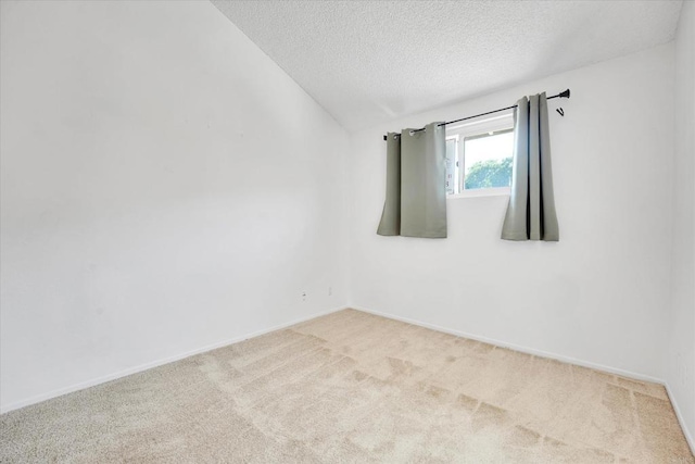 7077 Camino Pacheco, San Diego, CA 92111 - empty room featuring carpet floors, a textured ceiling, vaulted ceiling, and baseboards