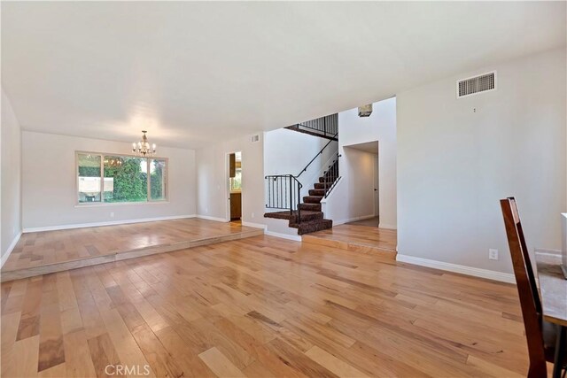 6164 Amberwood Dr, Rancho Cucamonga, CA 91701 - unfurnished living room with a chandelier, light wood-style floors, stairs, and baseboards