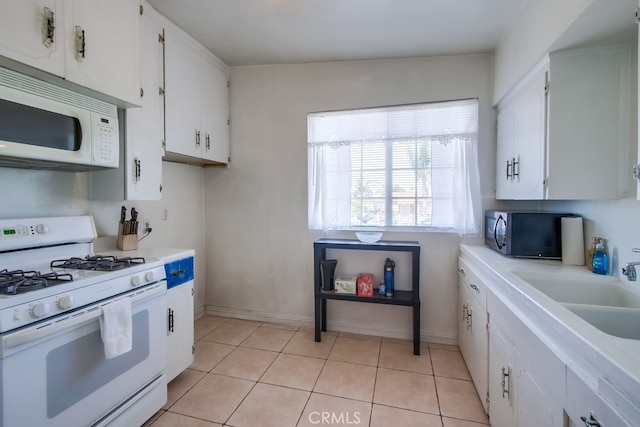 327 S 35th St, San Diego, CA 92113 - kitchen with white appliances, light countertops, white cabinetry, and light tile patterned flooring