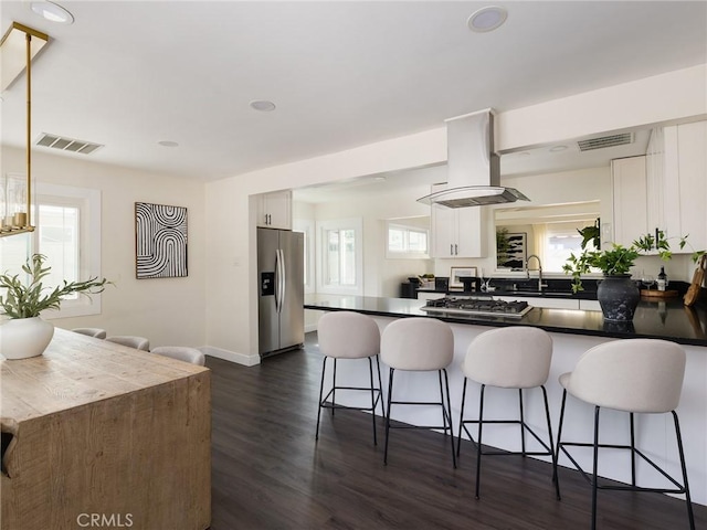 5512 W 117th St, Hawthorne, CA 90304 - kitchen with appliances with stainless steel finishes, island exhaust hood, white cabinetry, a breakfast bar, and a peninsula