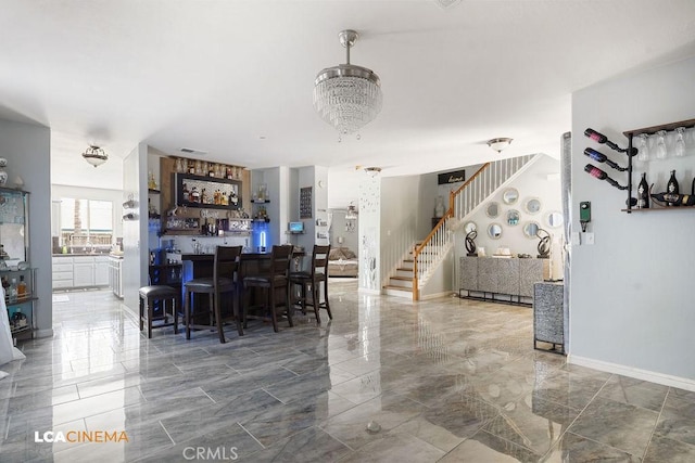 11703 Revolution Rd, Bakersfield, CA 93312 - dining room with stairs, marble finish floors, bar area, and baseboards