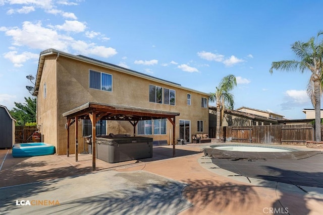 11703 Revolution Rd, Bakersfield, CA 93312 - rear view of house featuring a hot tub, a fenced backyard, stucco siding, and a patio