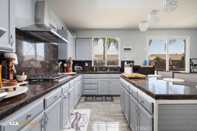11703 Revolution Rd, Bakersfield, CA 93312 - kitchen featuring wall chimney range hood, stainless steel gas cooktop, gray cabinets, a sink, and decorative backsplash